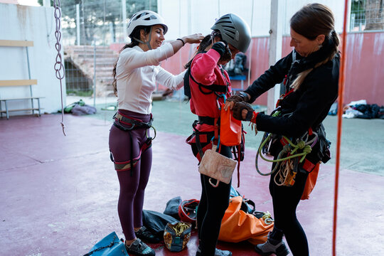 Women prepare climbing gear during indoor caving training