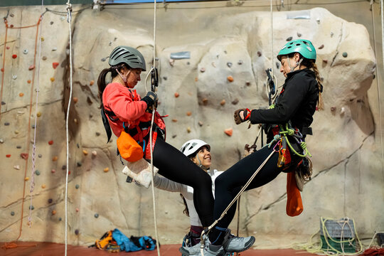 Women practice rope ascent during indoor caving training