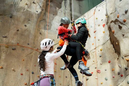 Women practice indoor climbing and vertical rope training