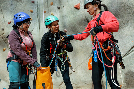 Women prepare climbing rope during indoor climbing training