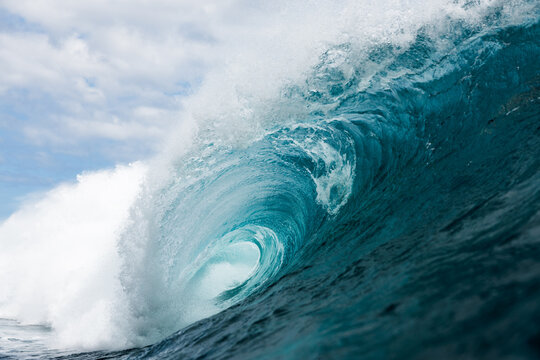 Powerful ocean wave curling into barrel with sea spray