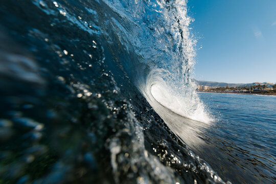 Close-up view of breaking ocean wave near sunny coast