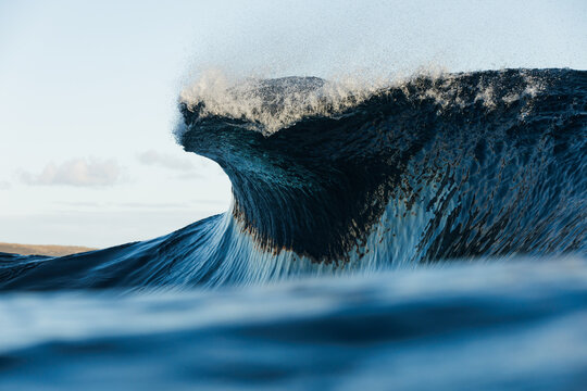 Powerful ocean wave curling with spray in coastal sea