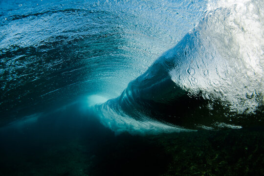 Underwater view of ocean wave barrel with sunlight glow