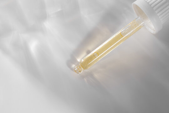 Cosmetic pipette with golden gel and caustic light effect