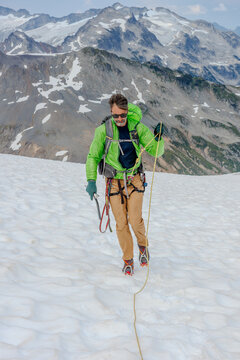 Man walking on glacier with rope