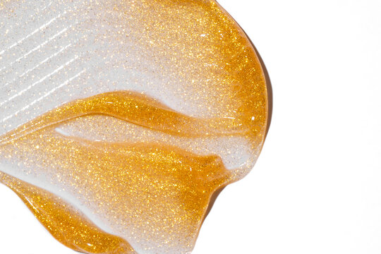 Gold glitter cosmetic smear on a white background