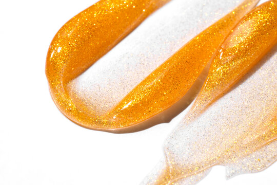 Gold glitter cosmetic smear on white background texture