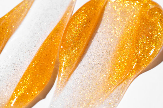 Gold glitter cosmetic smear texture on white background