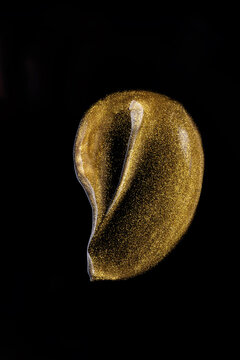 Gold cosmetic oil texture on black background