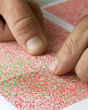 Color blindness test book hand page eye care optometrist macro test pattern red green