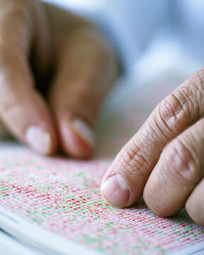 Color blindness test book, macro hands, clinical daylight, red green dot matrix, eye care concept
