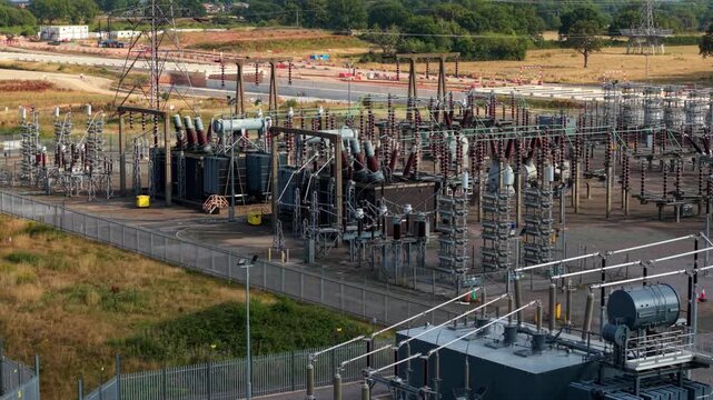 Detailed aerial close up view of electrical substation transformers and high voltage transmission lines
