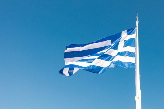 Greek flag waving in clear blue sky