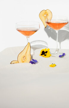Two rose wine glasses with summer cocktails and dried fruit appetizers