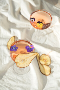 Two rose wine glasses on white fabric top view. Summer cocktails