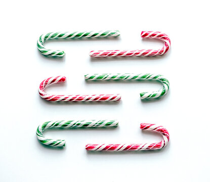 Red and green candy cane on white festive background