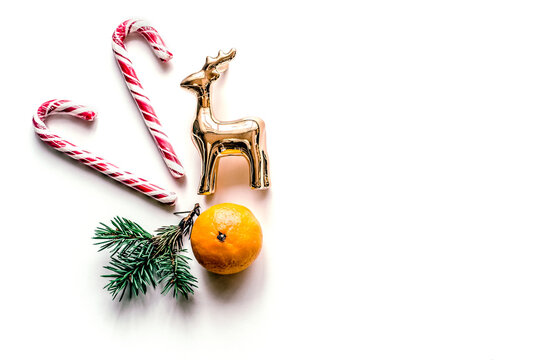 Christmas candy cane and golden reindeer with tangerine