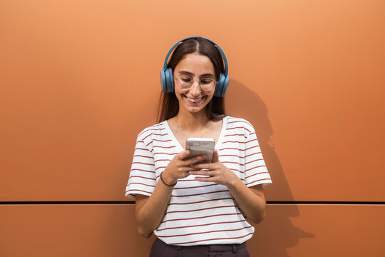 Woman in headphones using smartphone with smile