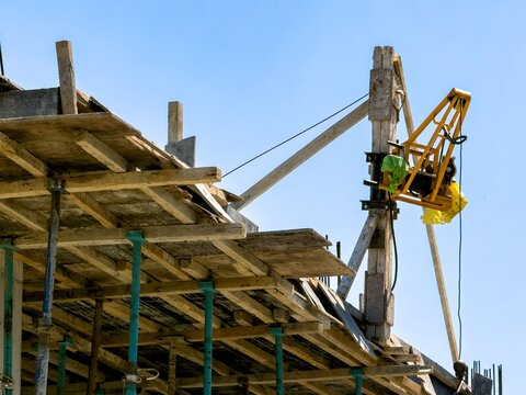 Construction site with wooden formwork and concrete hoist