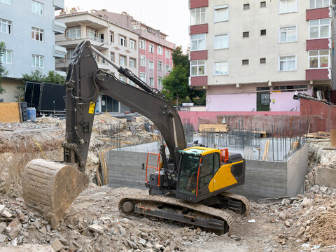 Excavator at urban residential building construction site