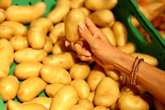Main choisissant une pomme de terre sur un &eacute;tal de march&eacute;