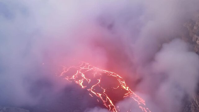 Erta Ale volcano, View of the glowing lava lake inside the crater, with molten rock patterns and dark volcanic rock walls in Zone 2, Afar, Ethiopia.