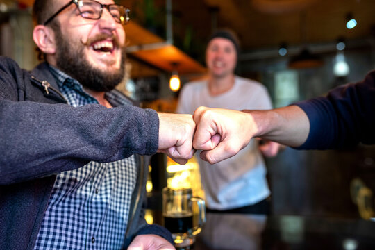 Joyful friends fist bumping celebration
