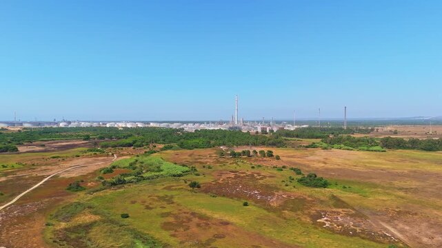 Oil refinery and green landscape in Sines, Portugal. Aerial view, distant shot. Moving forward