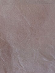 Fototapeta premium Crumpled light pink paper texture background surface close up