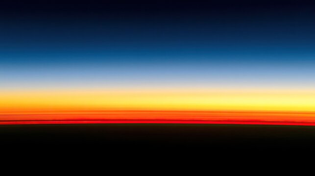 Horizon ablaze with vibrant sunset gradient above dark earth