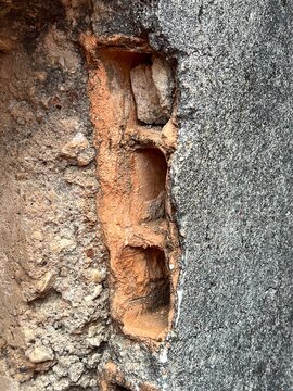 Exposed Hollow Clay Brick in Weathered Concrete Wall Close Up