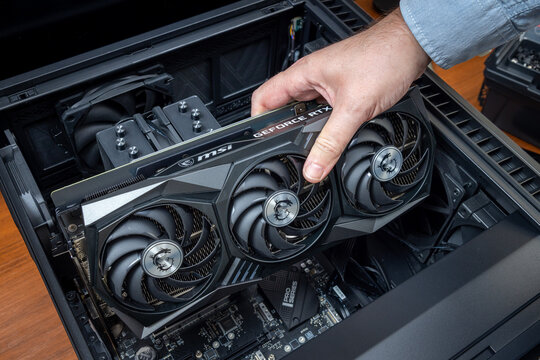Technician installs a powerful expensive MSI GeForce RTX graphics card into a high-end gaming PC or graphics workstation. Pavlodar, Kazakhstan - December 15, 2025
