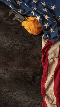Work glove and wrench with American flag on wood background. Symbolic of blue collar workers, USA manufacturing, pride in products Made in United States of America, or Father's day or US Labor Day.