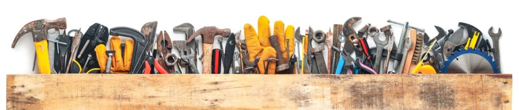 Group of worn work tools. Collection of used blue collar work equipment covered with old board. For home improvement, diy repair projects, Father's day gift ideas, or to celebrate Labor Day.