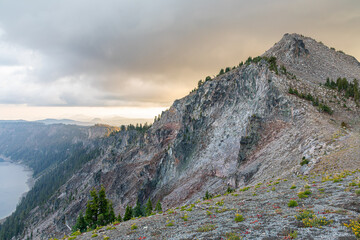Fototapeta premium Misty rocky hillside on Crater Lake Rim in the sunset