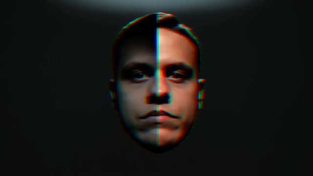 Slow motion rotating male face portrait with split color glitch effect centered frontal view subtle head rotation and chromatic split lighting in dark studio setting