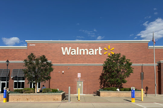 Novi, Michigan, US - Jul 23, 2026 : Front view of a modern Walmart retail store exterior featuring red brick architecture, storefront awnings, and a bright blue sky.