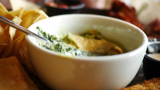 Dipping Chips in Guacamole in Bowl in Restaurant