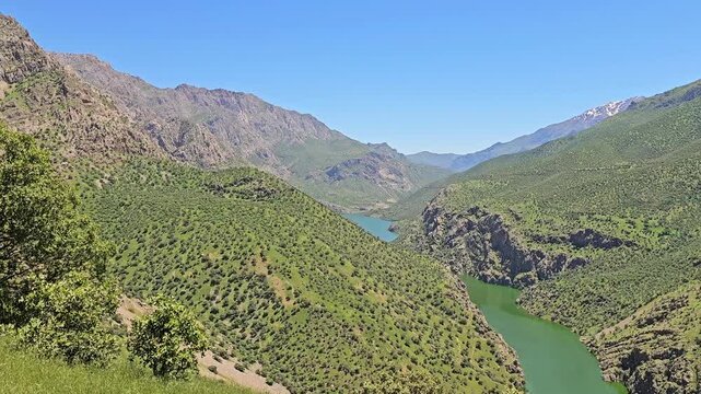 A deep-green river winds through a narrow gorge, flanked by tree-dotted slopes and rugged peaks with lingering patches of snow.
📍 Hawraman Takht, Kurdistan, Iran 