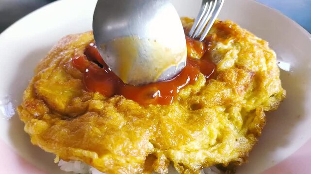Eating Thai omelet with rice, indoor Chiangmai Thailand.