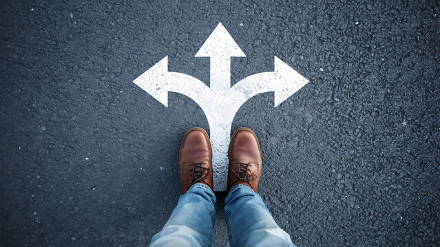 Person standing on asphalt looking at a painted three way arrow junction