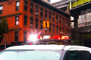 A dramatic low-angle shot of a police car with active emergency flashing lights in a dark urban city street, highlighting intense atmospheric law enforcement presence.  © kareem