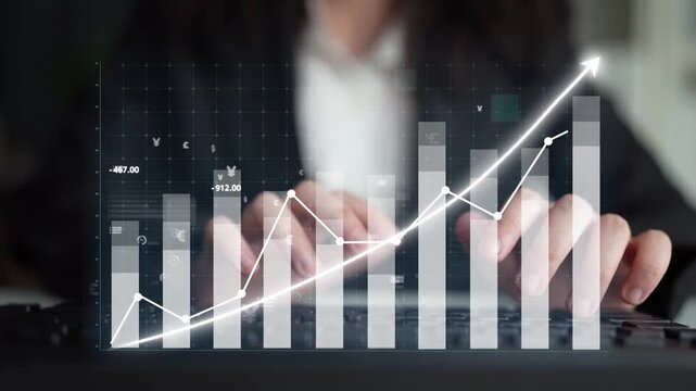 A business professional analyzes financial data trends on a computer. The image showcases a graph visualization representing growth, investment, and success in finance. Copula