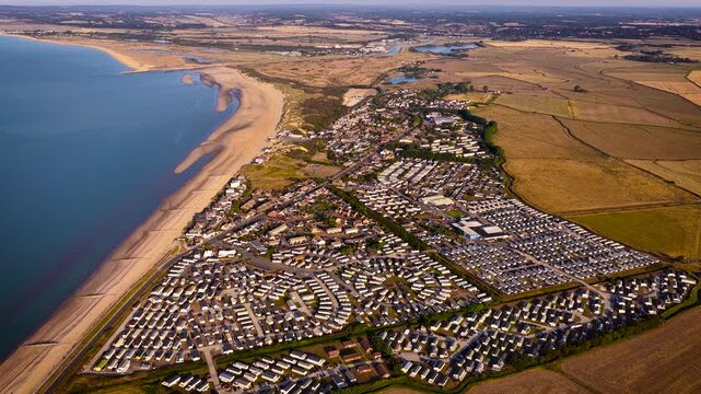 Aerial view of Camber Sands and coastal caravan parks beside farmland in East Sussex; ideal for travel, tourism, property, holiday and lifestyle advertising