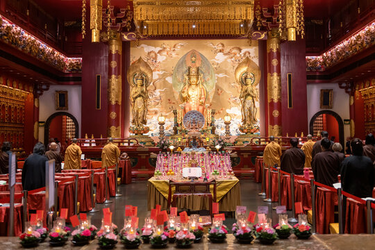 Monks and  people pray to Gold  statues in Buddha tooth relic temple, Singapore