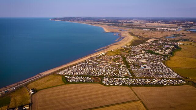 Aerial view of Camber Sands and coastal caravan parks beside farmland in East Sussex; ideal for travel, tourism, property, holiday and lifestyle advertising