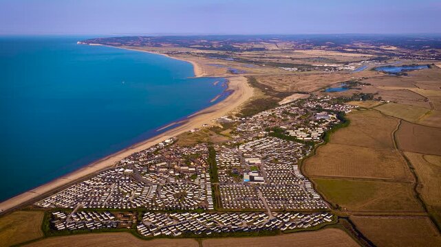 Aerial view of Camber Sands and coastal caravan parks beside farmland in East Sussex; ideal for travel, tourism, property, holiday and lifestyle advertising