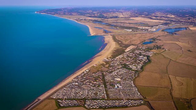 Aerial view of Camber Sands and coastal caravan parks beside farmland in East Sussex; ideal for travel, tourism, property, holiday and lifestyle advertising