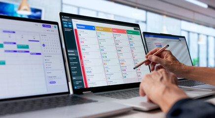 Older Woman Updates Project Tasks On Laptop While Pointing